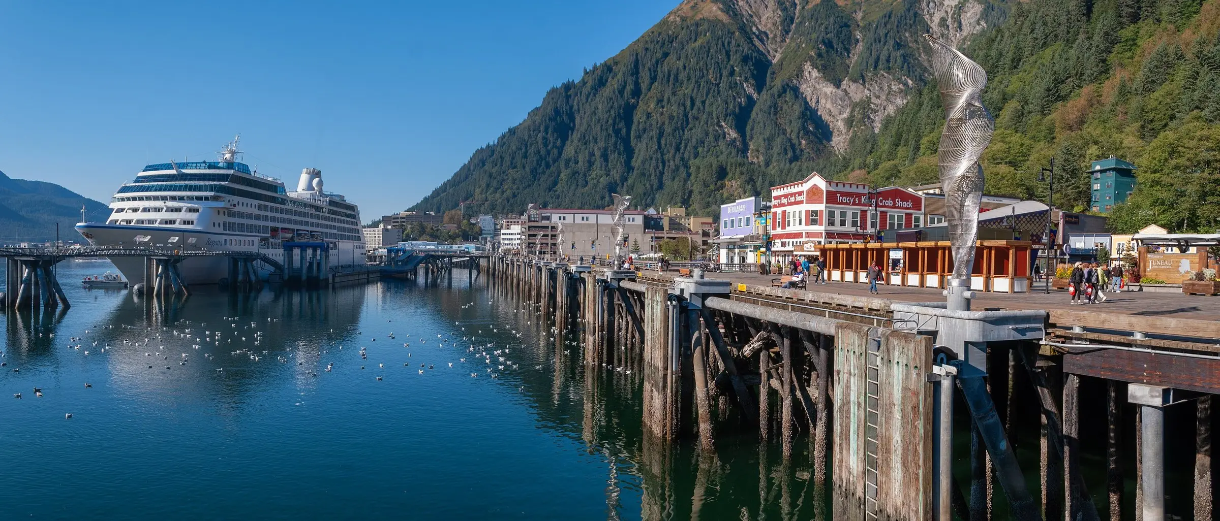 A cruise ship docked at Juneau, Alaska, beside the waterfront and the forested mountainside