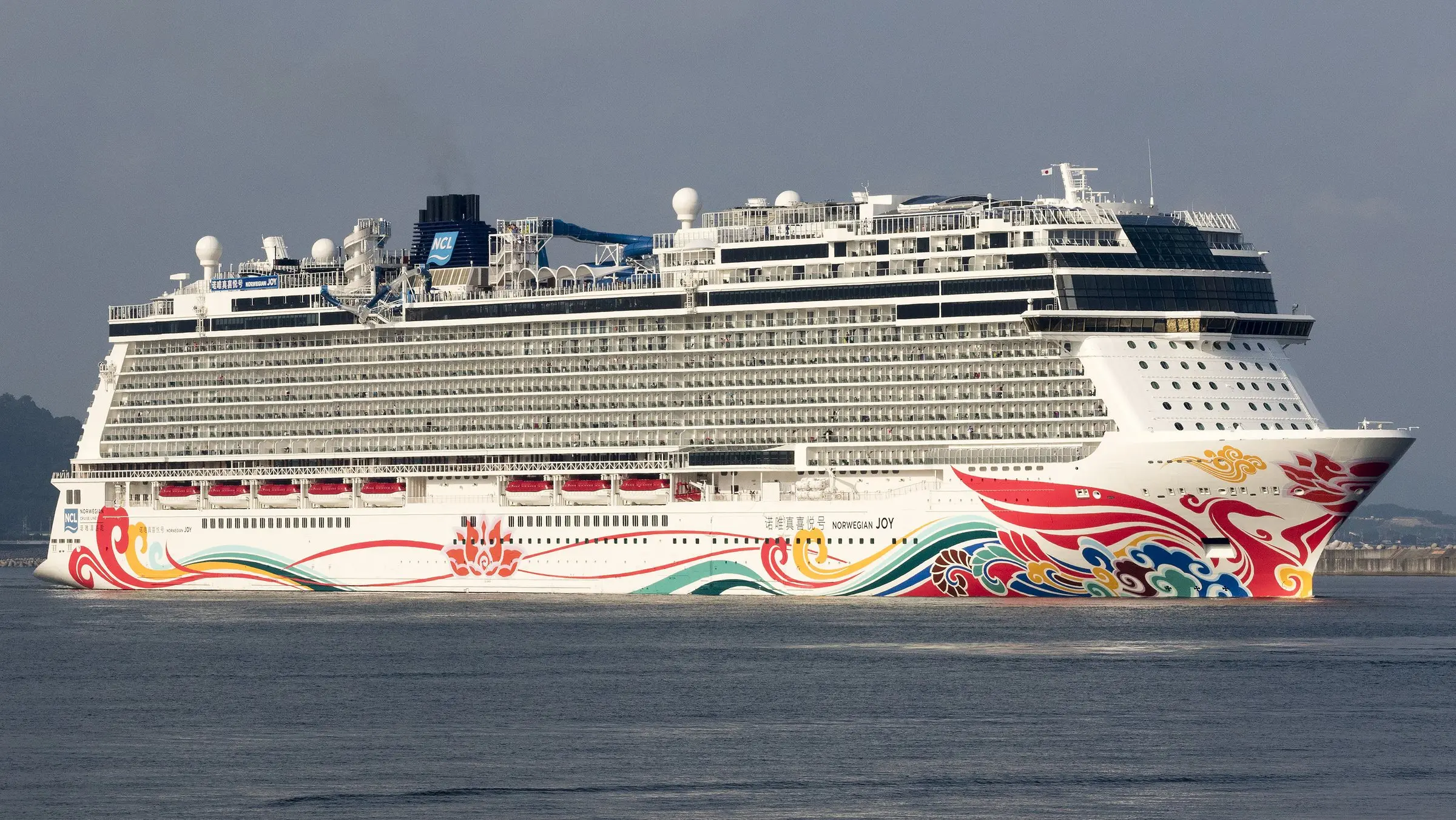 Norwegian Joy at the new cruise port in Kochi, seen side-on with its painted hull