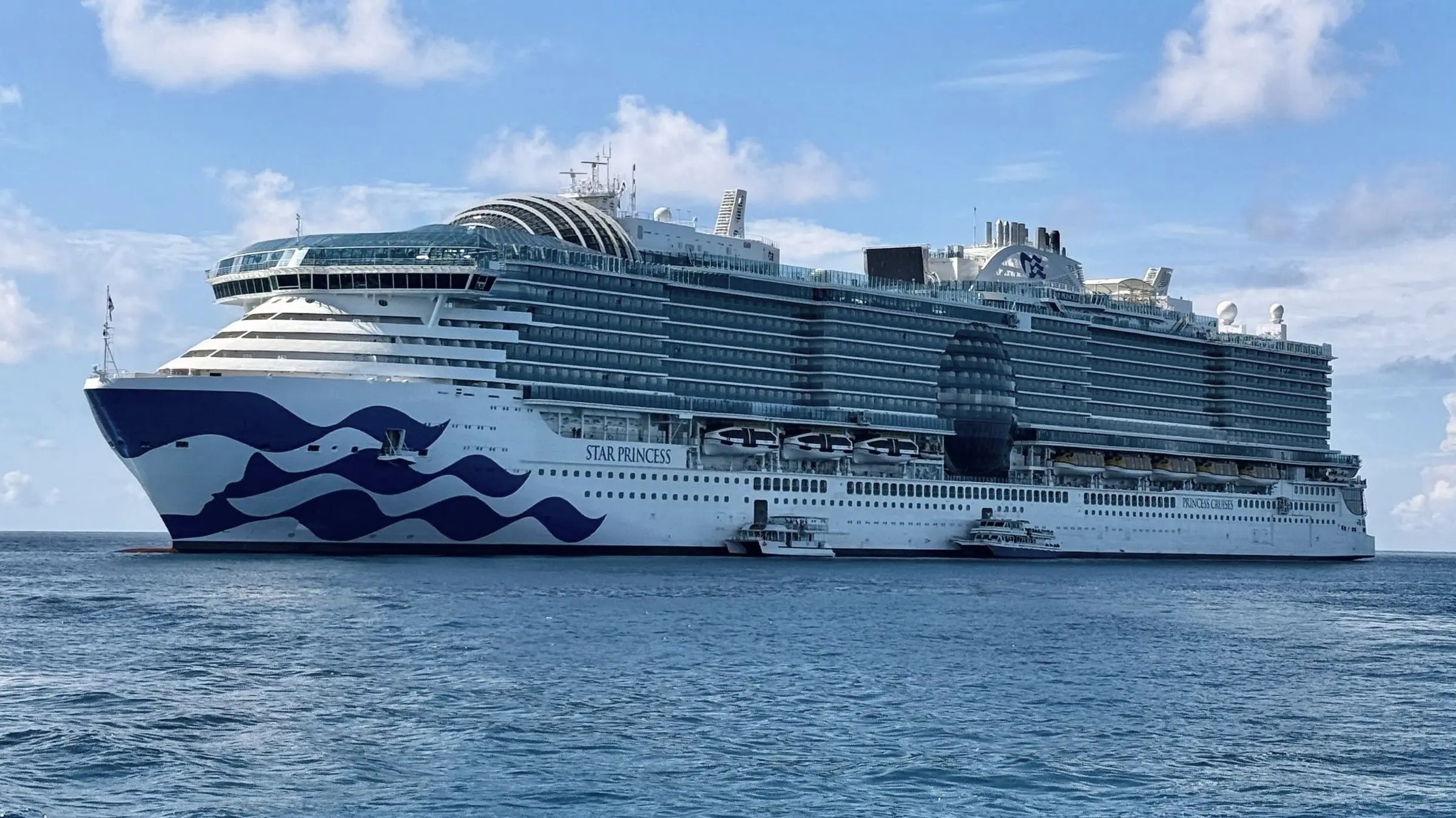 Star Princess, the 2025 Princess ship, at anchor in blue water, seen side-on